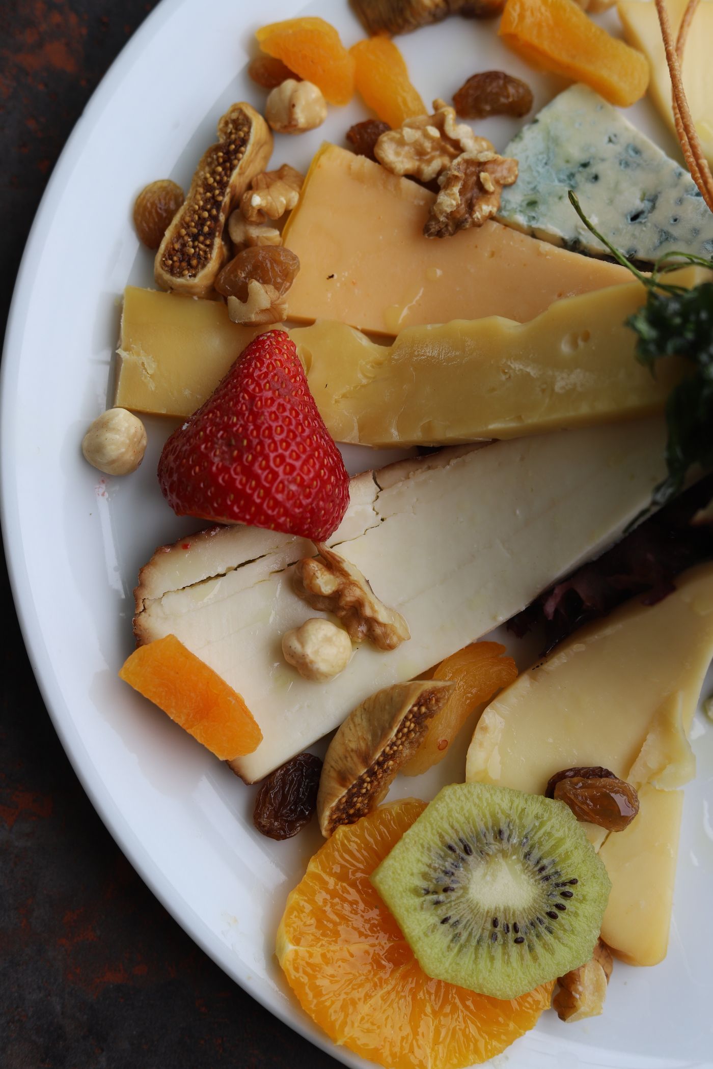 Bord met gevarieerde kazen, gedroogd fruit en noten